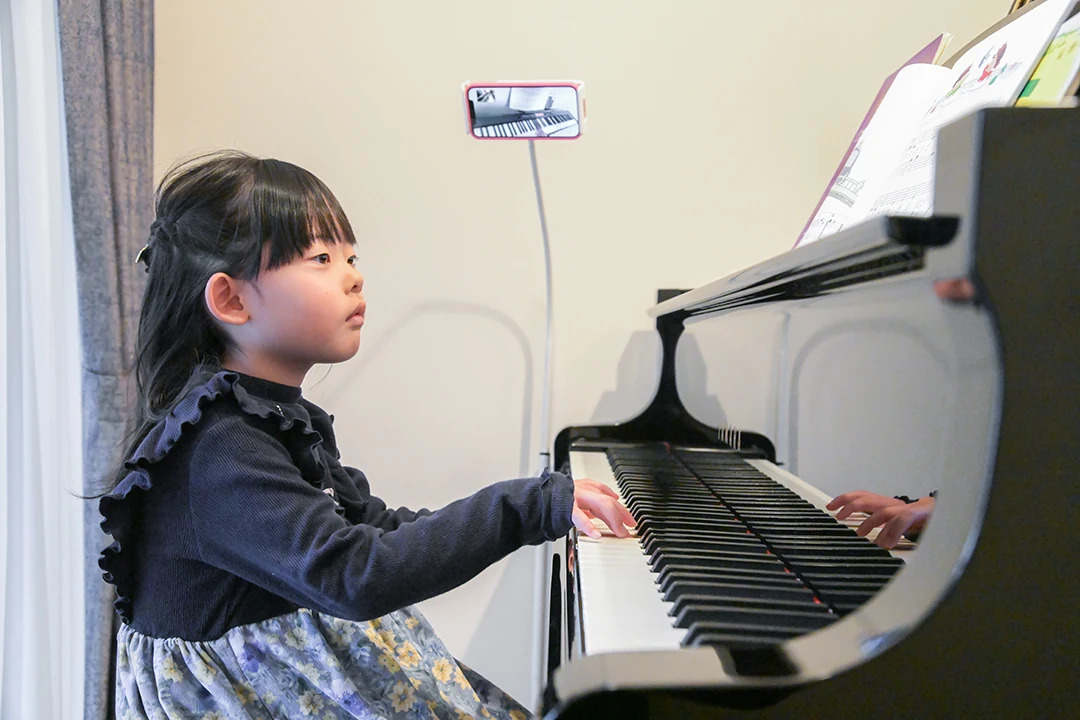 自宅でピアノを弾く幼い生徒